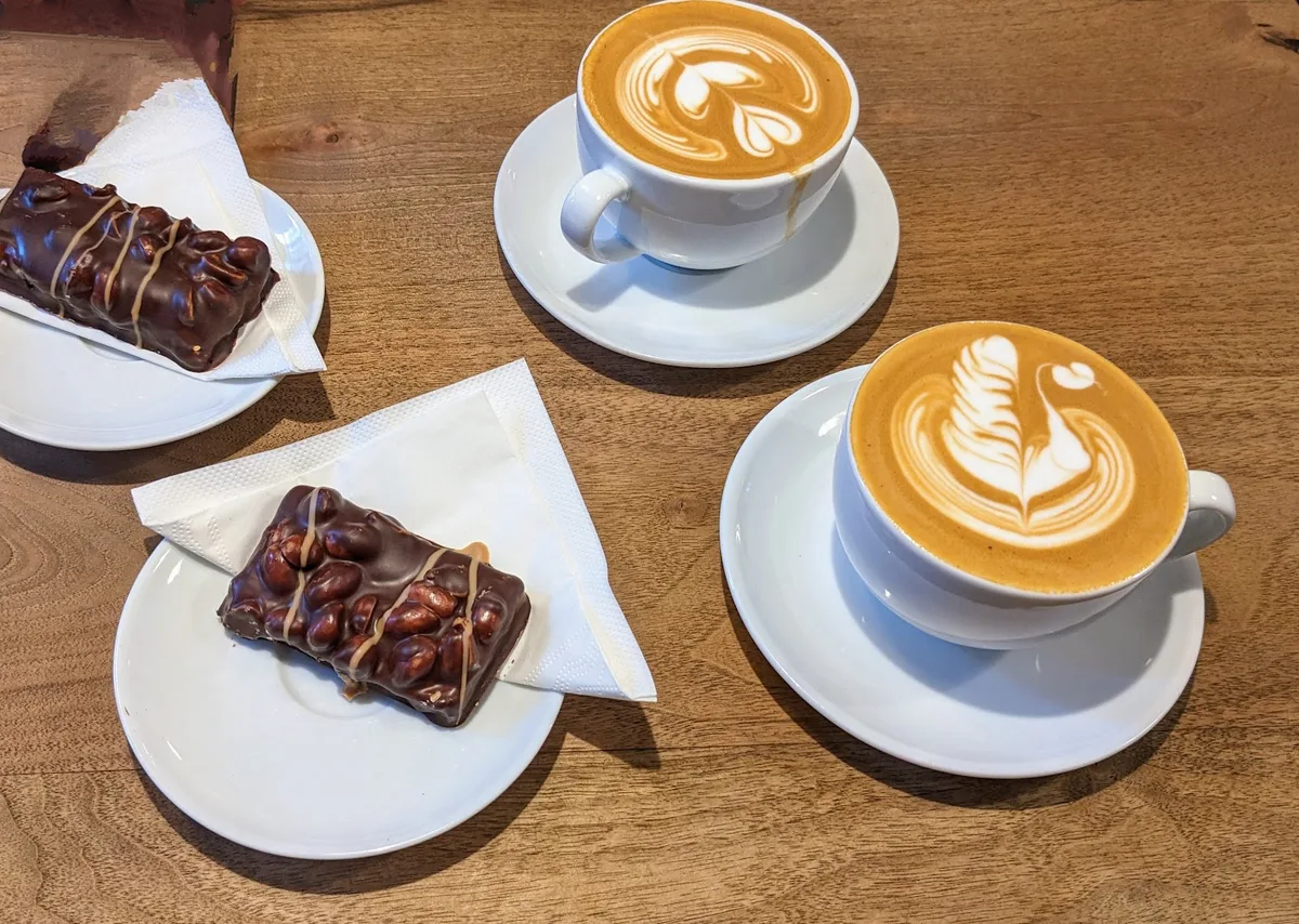 To cappuccino og chokoladesnitter på træbordet